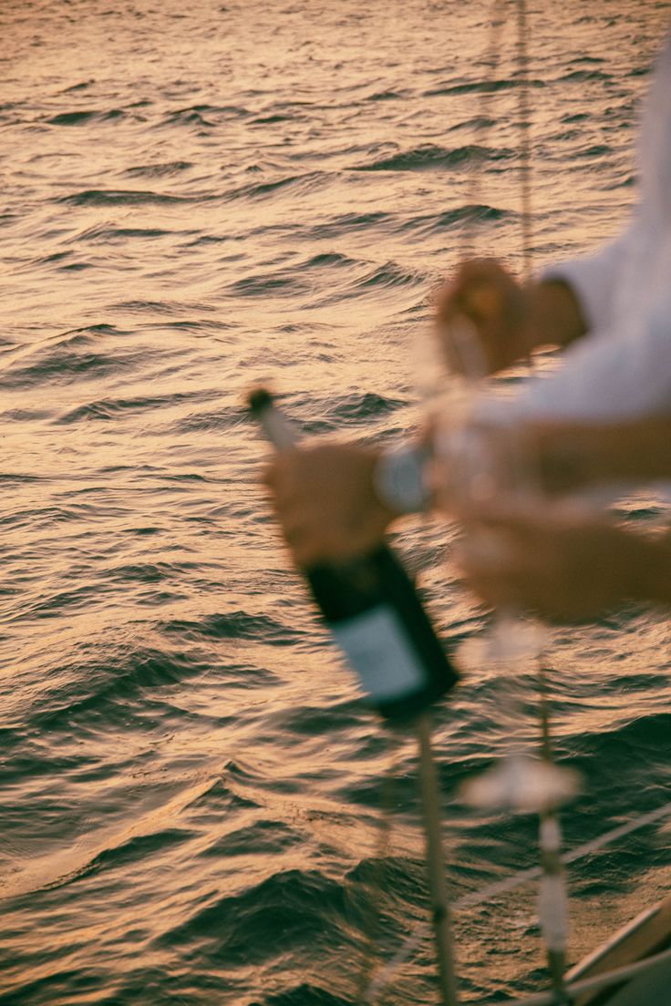 Champagne is poured beside the sea at sunset